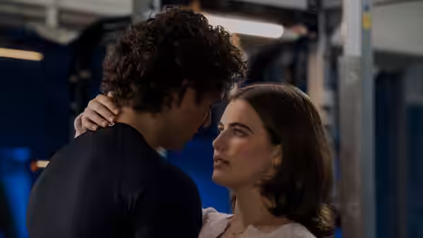 Young man and woman stand face to face in a gym