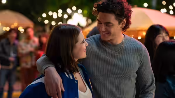 Couple with arms around each other at an outdoor night gathering