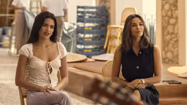 Oriah (Maia Reficco) and Isolde (Eva Longoria) seated indoors in conversation