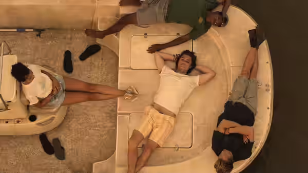 John B (Chase Stokes) relaxing on a boat with friends