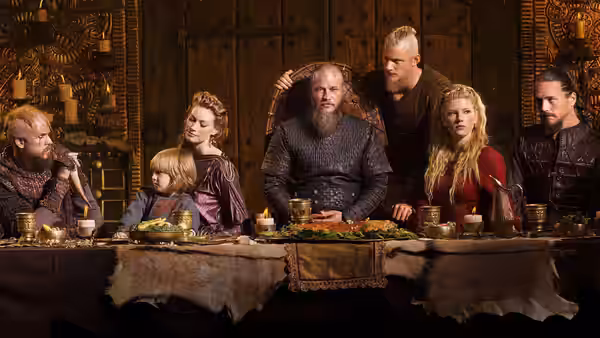 Vikings gathered around a long feast table in a wooden hall