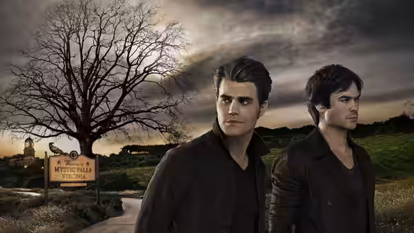 Two men stand before a welcome sign to Mystic Falls Virginia at dusk