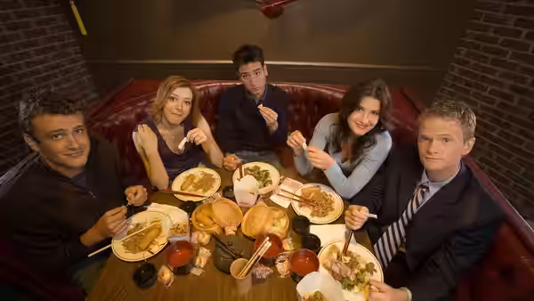 Ted, Lily, Barney, Robin and Marshall eating at a restaurant table