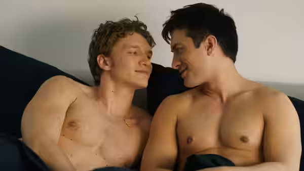 Ilya Rozanov and Shane Hollander sit shirtless together in bed