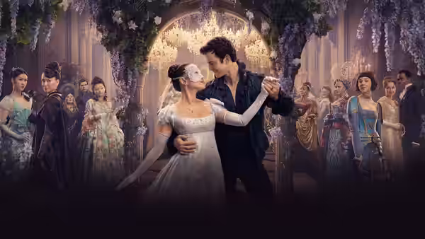 A masked woman in white dances closely with a man amid guests in a grand hall