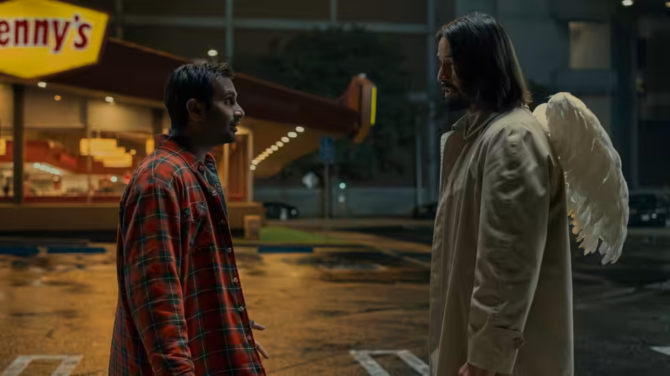 Gabriel (Keanu Reeves) facing a man in red plaid shirt on wet street at night