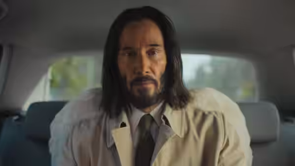 Gabriel (Keanu Reeves) seated in the back seat of a car looking ahead