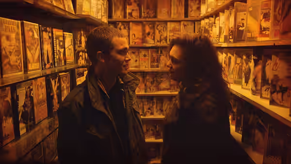 Murphy (Karl Glusman) and Electra (Aomi Muyock) facing each other in a video store