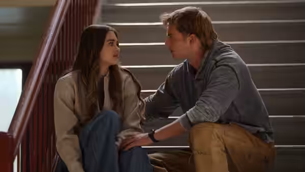 Young woman and man sitting close together on indoor staircase