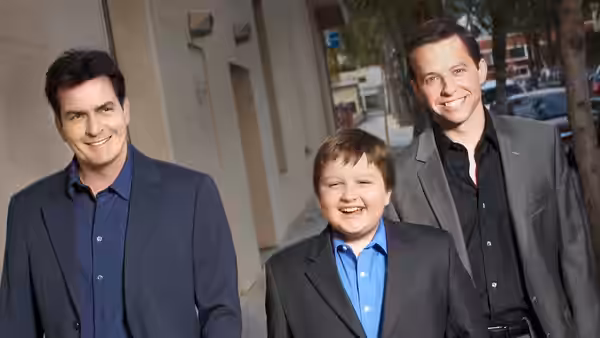 Charlie Harper, Jake Harper and Alan Harper in suits standing outside a building