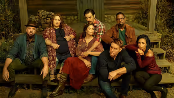 Toby (Chris Sullivan) sits with Kate (Chrissy Metz) and family on cabin steps