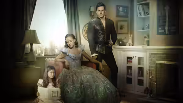 Snow White (Ginnifer Goodwin) seated beside Prince Charming (Josh Dallas) and a young girl