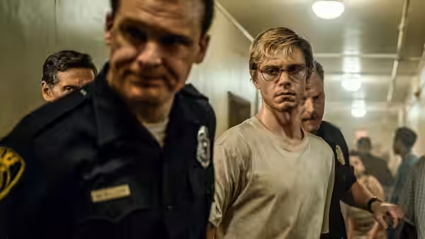 Jeffrey Dahmer (Evan Peters) walks down a hallway escorted by police officers