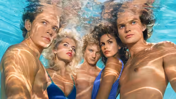 Five people looking toward the camera while submerged in a swimming pool