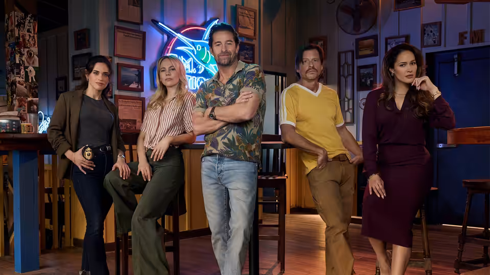 R.J. Decker (Scott Speedman) stands with arms crossed among four others in a bar