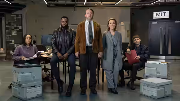 John Taylor (David Mitchell) with four colleagues posing in an office