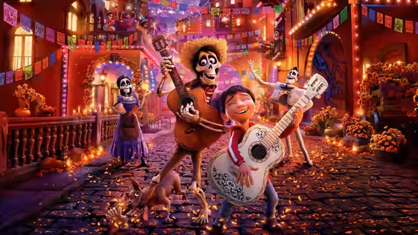Miguel and Héctor play guitars while dancing in a festive street