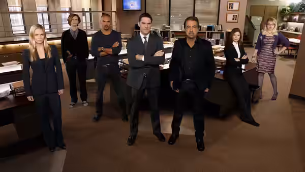 Group of agents standing in a large modern office with wooden desks