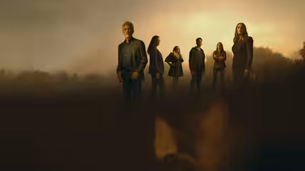 Group of people standing in a line on a misty hillside at dusk