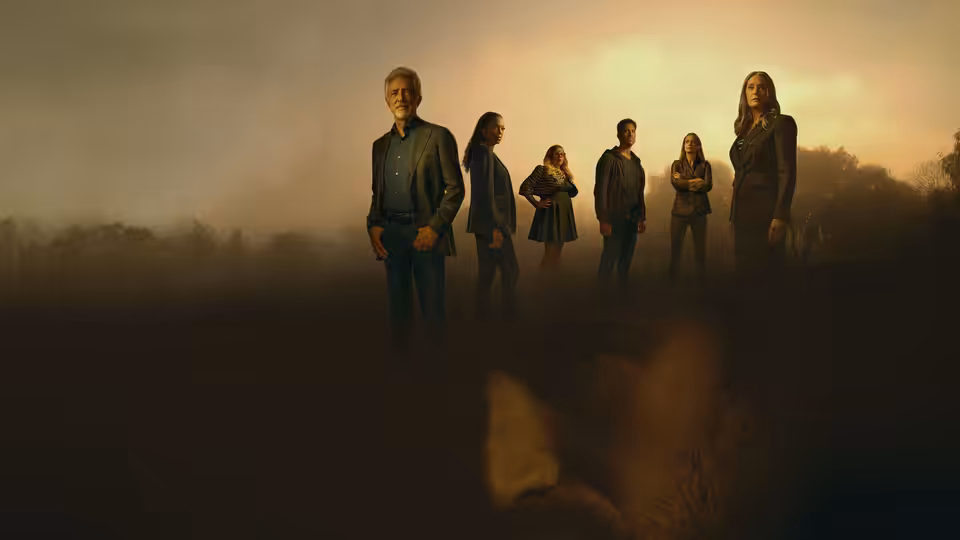 Group of people standing in a line on a misty hillside at dusk