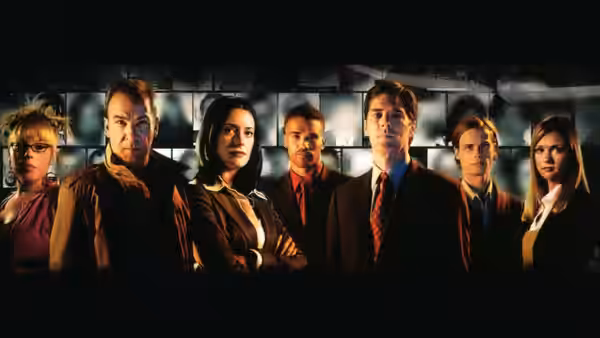 Six investigators standing side by side against a dark brick wall