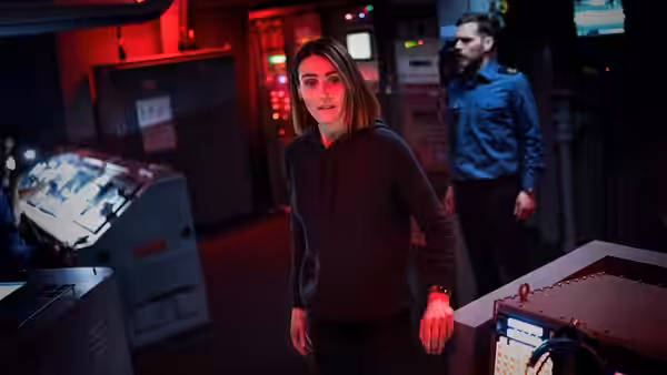 DCI Amy Silva (Suranne Jones) walks through a red-lit control room