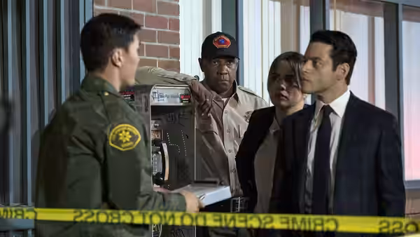 Officers and Rami Malek gather at a crime scene with yellow tape