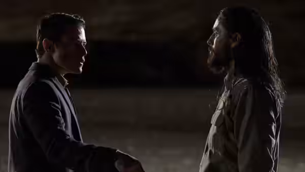 Rami Malek and Jared Leto stand face to face outdoors at night