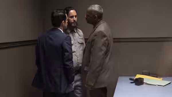 Rami Malek, Jared Leto and Denzel Washington talk in a small room