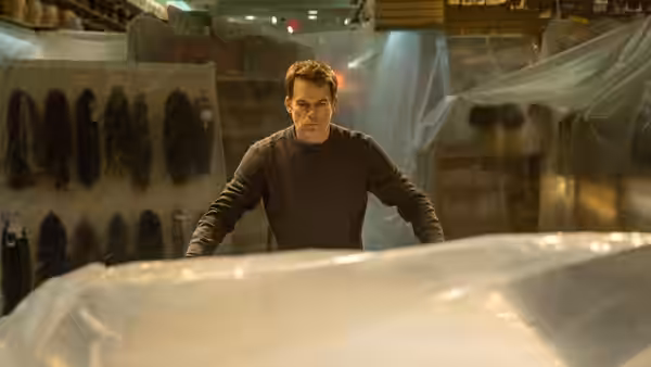 Dexter Morgan (Michael C. Hall) standing amid plastic sheets in a lab