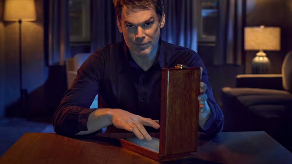 Dexter Morgan (Michael C. Hall) opening a wooden box on a table