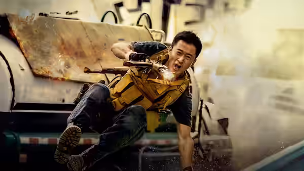 Leng Feng (Wu Jing) tumbles beside an armored vehicle while gripping his rifle