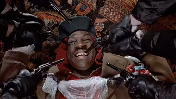 Billy Ray Valentine (Eddie Murphy) lying down with guns pointed at his head