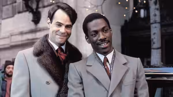 Louis Winthorpe III (Dan Aykroyd) and Billy Ray Valentine (Eddie Murphy) standing together outdoors