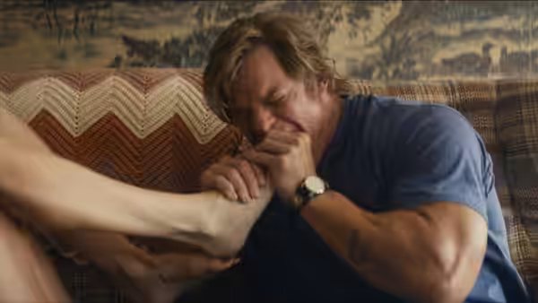 Man on couch pressing woman's foot against his face with eyes closed
