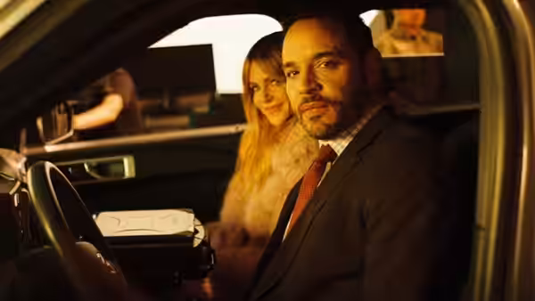 Adam Karadec drives at night while Morgan Gillory sits beside him in the car