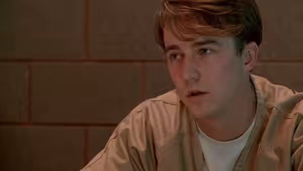 Aaron Stampler (Edward Norton) in a beige jumpsuit looking upward with concern