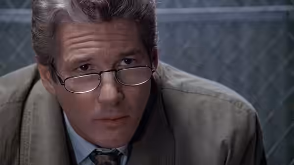 Martin Vail (Richard Gere) with glasses leaning forward in a serious expression