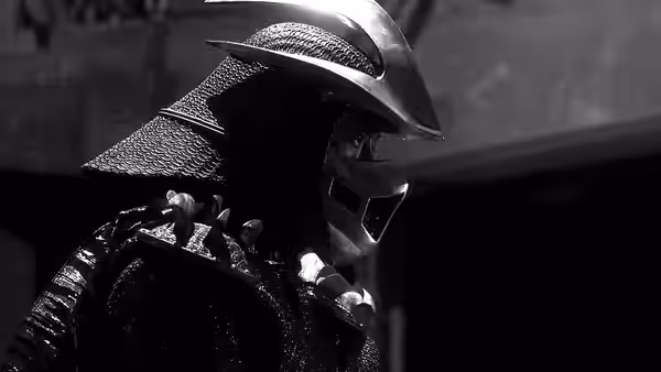 An armored figure in a metal helmet stands in profile