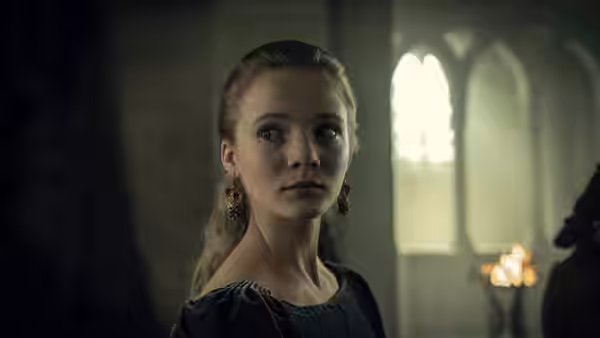Ciri (Freya Allan) standing in a stone chamber with arched windows