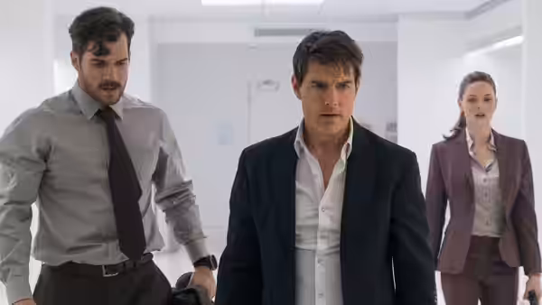 Ethan Hunt (Tom Cruise) walking through an office with August Walker (Henry Cavill)