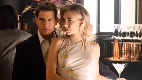 Ethan Hunt (Tom Cruise) seated beside The White Widow (Vanessa Kirby) at a bar