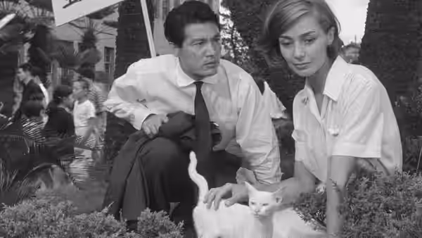Lui (Eiji Okada) and Elle (Emmanuelle Riva) sit beside a cat in a garden
