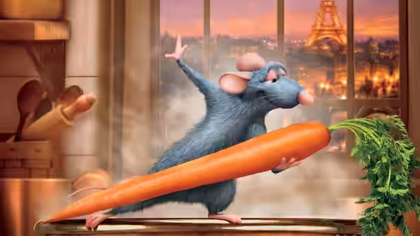 Remy grips a large carrot in a kitchen with the Eiffel Tower behind