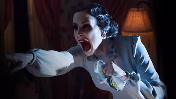 Renai Lambert (Rose Byrne) screams and points while clutching a small blanket