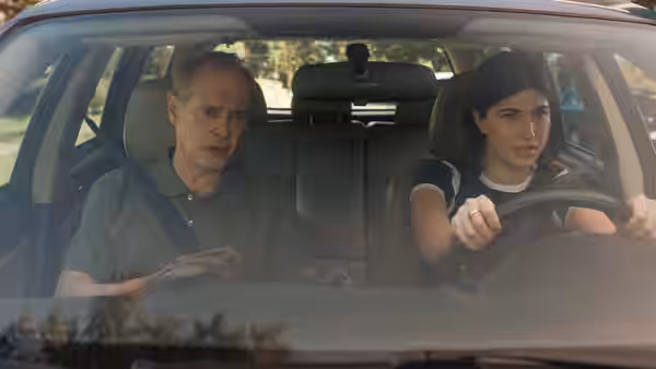 Steve Buscemi rides in a car driven by a young woman