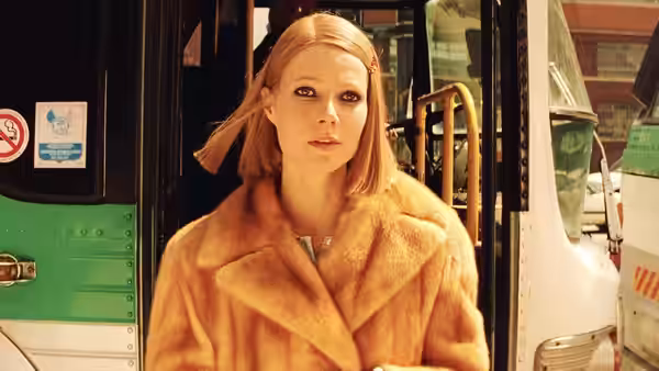 Margot Tenenbaum (Gwyneth Paltrow) stands before the open doors of a bus