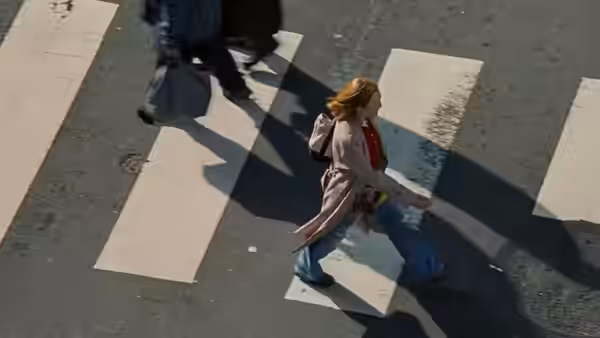 Mona (Julianne Moore) crosses city street on white crosswalk