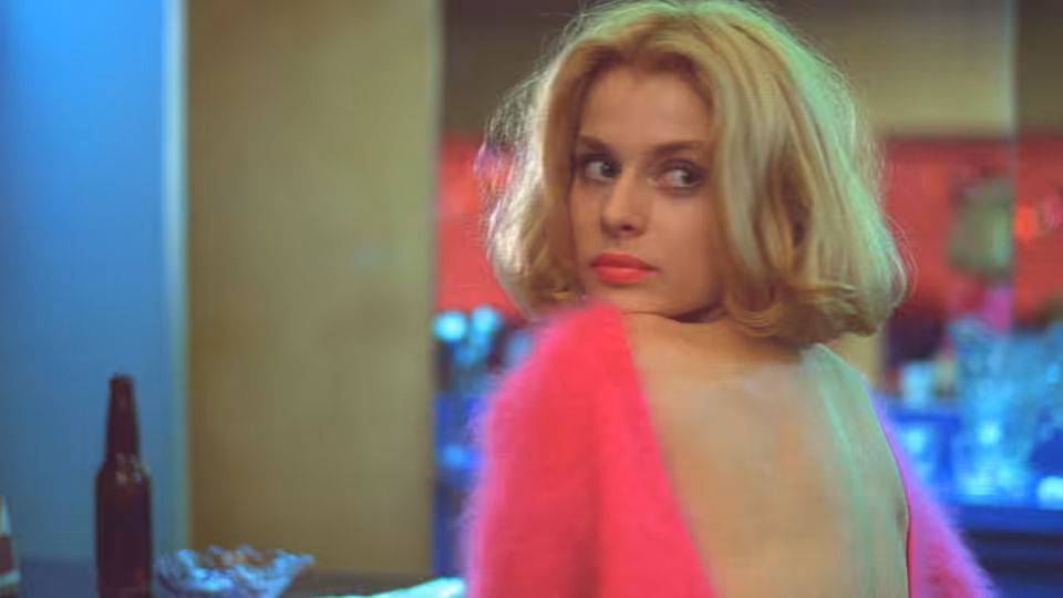 Jane (Nastassja Kinski) glancing back over her shoulder in a pink sweater