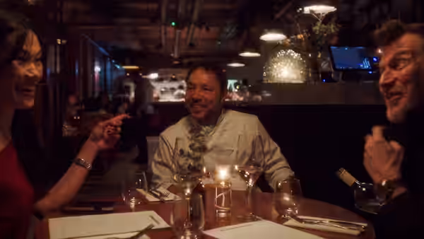 Andy Jones (Stephen Graham) seated at a restaurant table with two diners